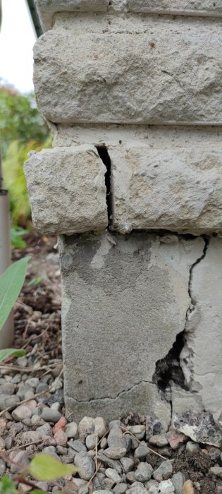 Spricka vid hörn på mur, synlig skada och behov av reparation.