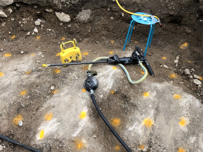 Bild på elinstallationer i en utgrävd byggarbetsplats med synliga kablar och skyddsgaller.