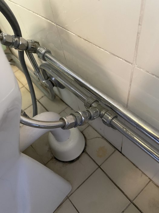 VVS-röranslutningar och mutter nära bidé i badrummet som användare vill ta bort.