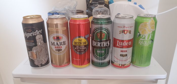 Ölburkar i olika färger och märken uppställda på ett kylskåp.