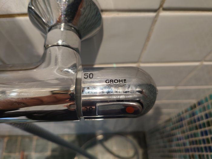 Närbild av ett kromat Grohe blandarhus i ett badrum, behöver hjälp att identifiera modellen.