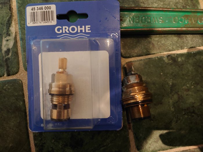 Ny och gammal flödesinsats för blandare på grön marmor, förpackningen märkt Grohe.