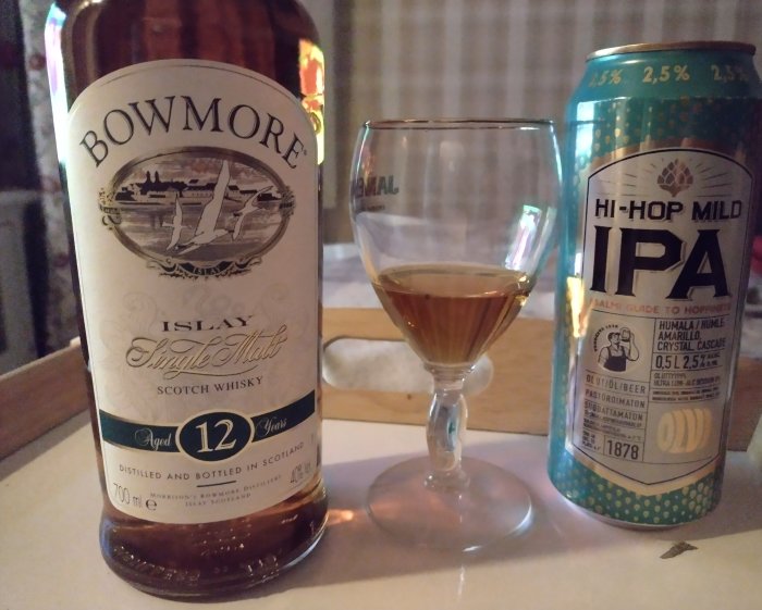 Flaska Bowmore Islay Single Malt Scotch Whisky bredvid ett glas whisky och en burk IPA öl.