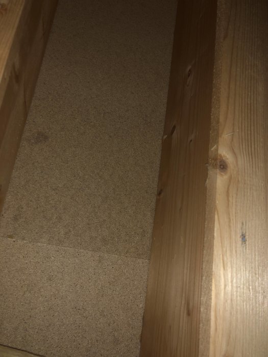 Undersida av golv med 22mm spån och träreglar, inga synliga skador eller fukttecken.