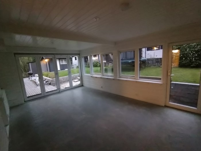 Det nybyggda uterummet med isolering, stora fönster och dörrar som öppnar upp mot trädäcket och trädgården.