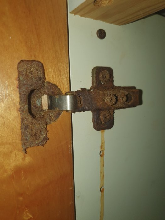 Starkt rostangripet metalldon på badrumskommod med synliga korrosionsspår och ärgning.