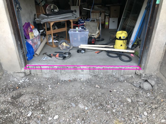 Garage med markerad linje över källargolvet där en framtida betongbalk skulle placeras för att stödja en vägg.