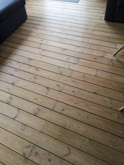 Obehandlad trätrall med synliga skruvar i en oisolerad veranda.