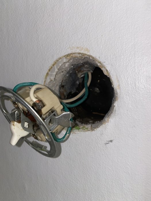 Öppnad väggdosbox av metall med elektriska kablar, för liten för att installera en dimmer.