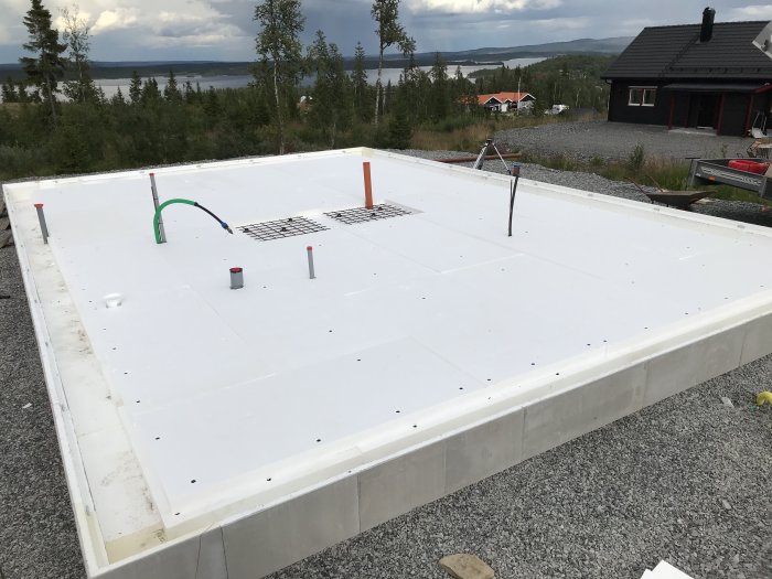 Konstruktion av platta på mark med BEWI 400mm L-kantelement och tre lager cellplast isolering, redo för betonggjutning.