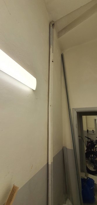 Skadat värmerör längs en vägg, misstänkt isolerat med asbest, vid en inspektion för renovering.