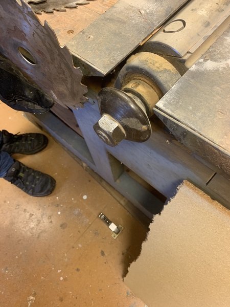Närbild av en gammal planhyvel i arbete, med synligt skärverktyg och träspån, indikerar användning och slitage.