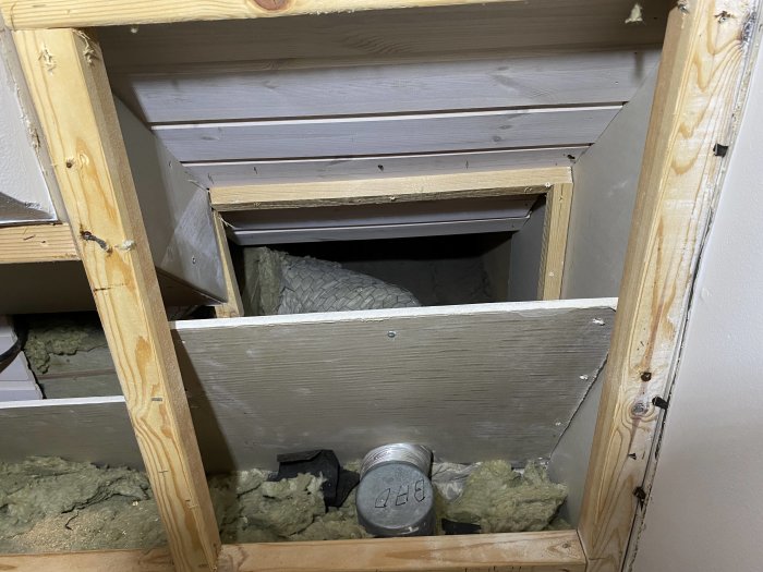 Öppen vägg på vind med synlig isolering, spikreglar och gipsskiva, brist på ångspärr.