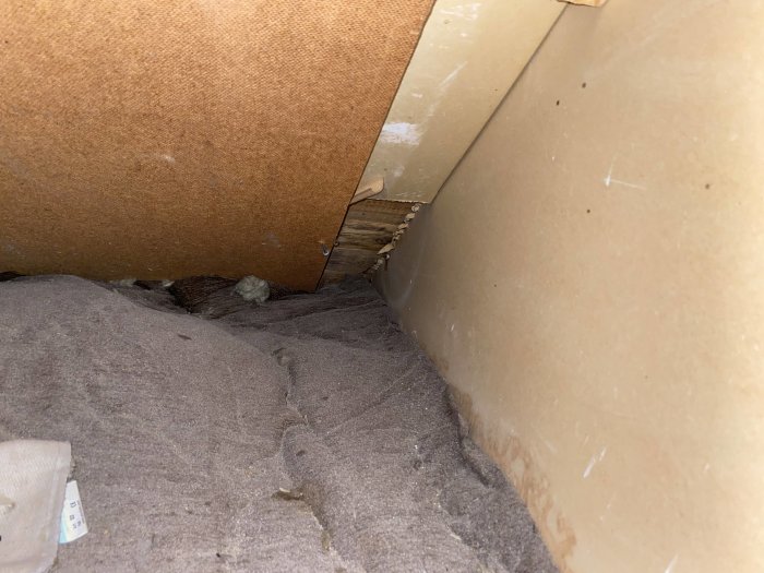 Isolerad vindsyta med synlig nedre del av en ångspärr ej dragen helt ned till golvet.