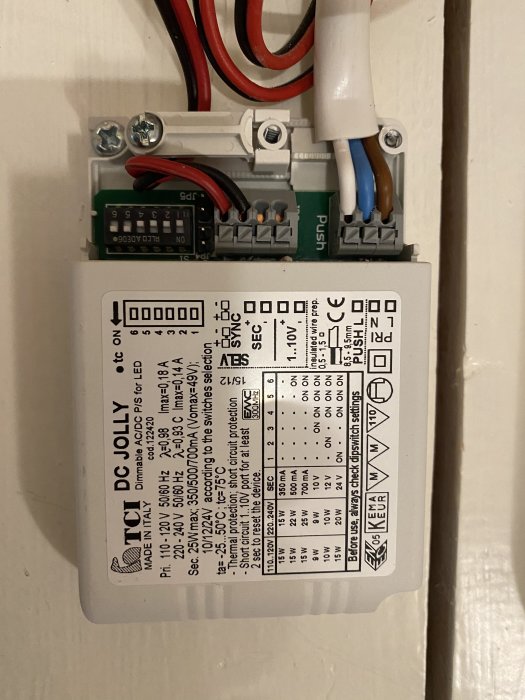 Närbild på en DC Jolly LED-drivdon med kablar anslutna och en etikett som detaljerar teknisk information.