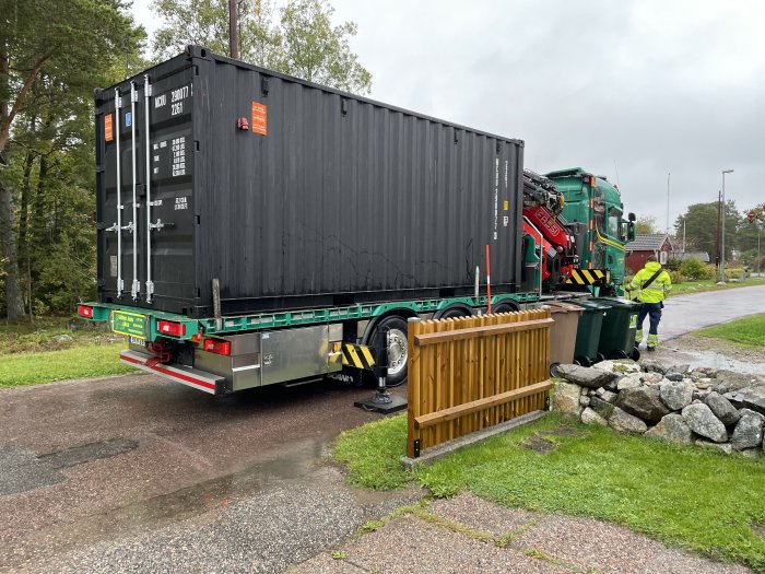 Isolerad container levereras på lastbil i Gävle medan en person i västarbetskläder observerar.