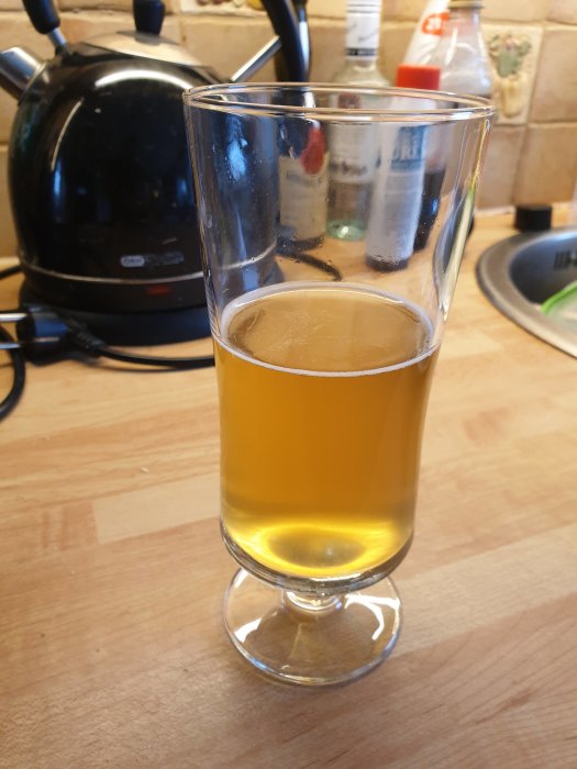 Ölglas med New England IPA på ett köksbord, smakprov innan tillsats av humle.