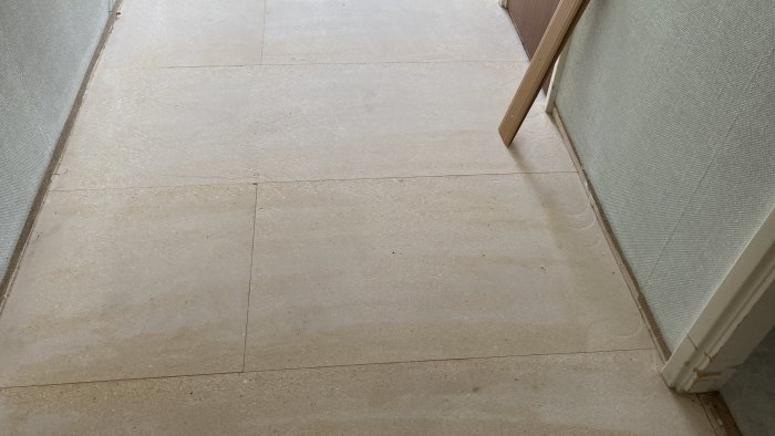 Chipboard floor panels arranged alternately, with some whole and some cut in half, in a hallway ready for repair to fix creaking.