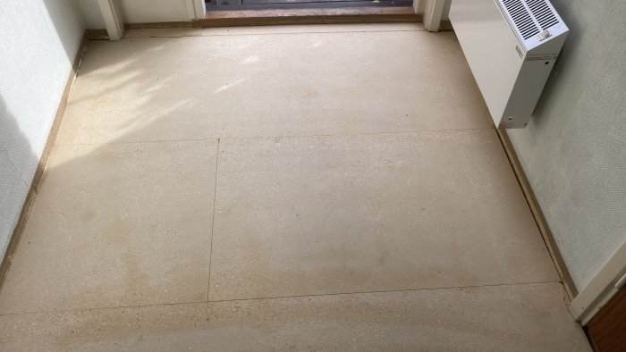 Wooden particle boards on a floor, some whole, others cut, with visible joints, part of a hallway renovation project to fix creaking sounds.