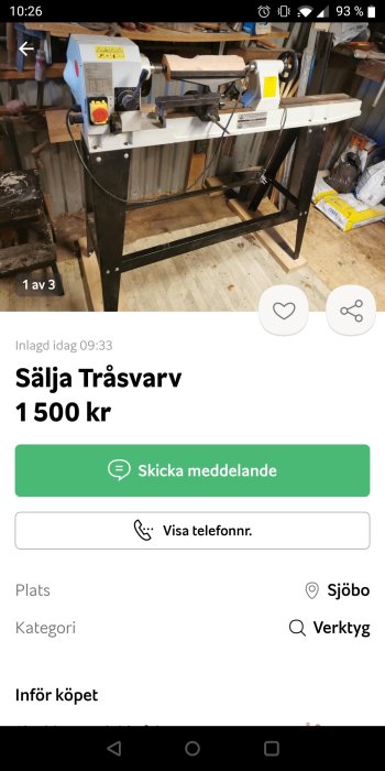 Träsvarv med blått och gult hus, monterad på svart ställning, inne i verkstad.