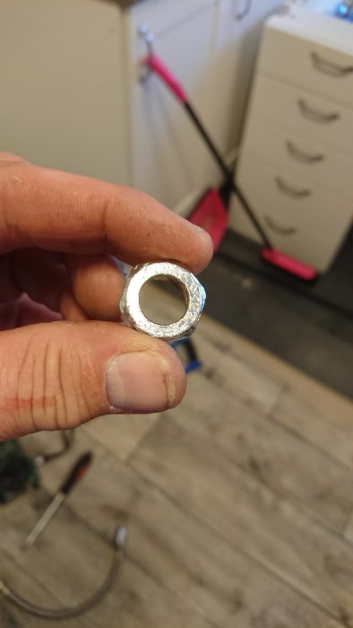 Närbild på en hand som håller en 10 mm klämring med fokus på klämringens form och storlek.