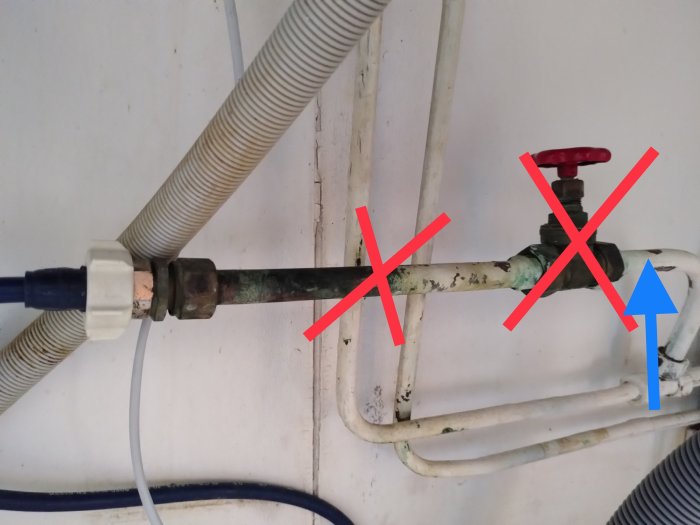 Vattenledningsinstallation med röda kryss som markerar delar att ta bort och en blå pil som visar anslutningspunkt.