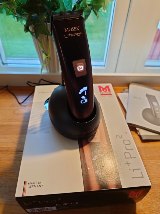 Ny Moser Li+Pro 2 hårklippare med diamond-blade står på sin förpackning bredvid ett fönster och en växt.
