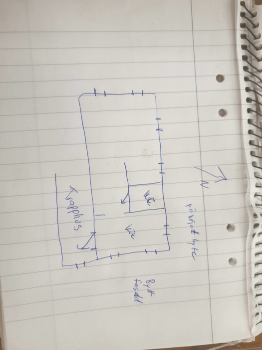 Handritad skiss av en lägenhetsplan på rutigt papper med markerade fönster och rum, inklusive WC och sovalkov.