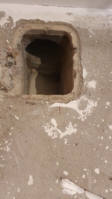 Äldre ventilationshål i betongvägg med bortsprängd sida för installation av frånluftsdon.