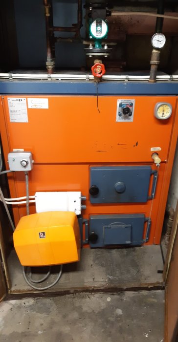 Kombipanna i ett pannrum med dragregulator kedja, cirkulationspump och tryckmätare.