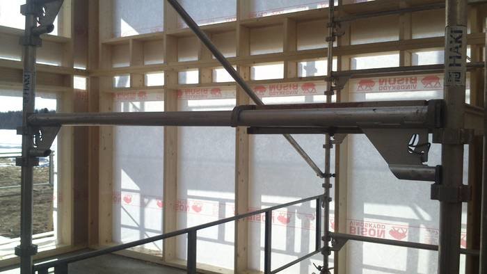 Konstruktionsdetaljer med regelvägg och stöttande ställning under byggnation.