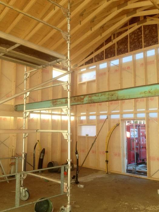 Interiör av fritidshus under renovering med synliga reglar och uppsatta byggställningar.