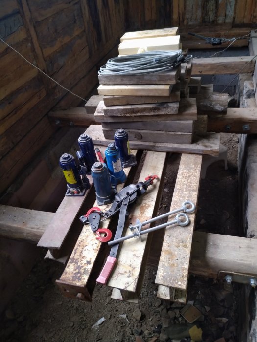 Renoveringsmaterial och verktyg på träbjälkar inne i ett pågående bygge.