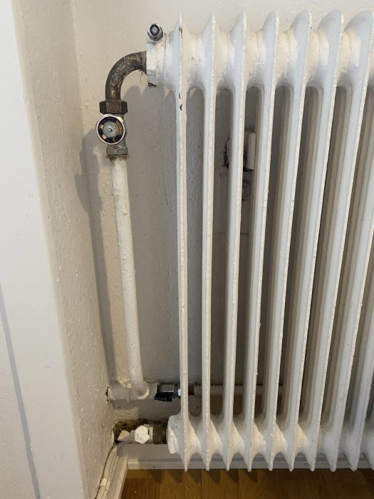Radiator med borttagen termostat och synligt Ballofixvred i ett flerfamiljshus.