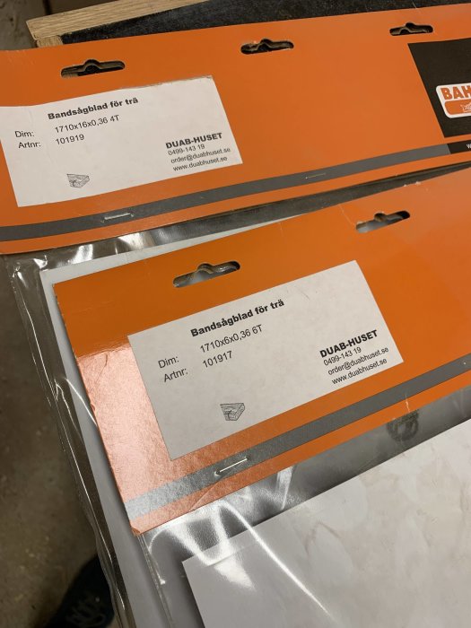 Oanvända bandsågblad för trä i förpackningar från DUAB-HUSET, etiketter visar dimensioner.