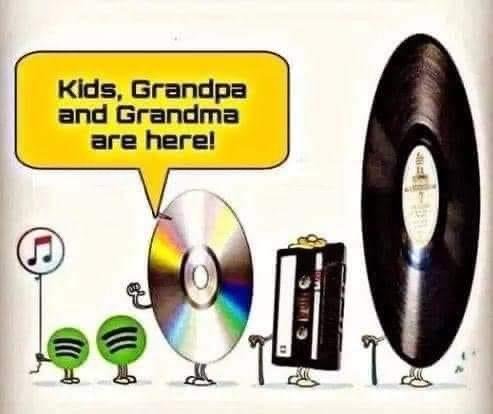 Comic illustration depicting an anthropomorphized CD and cassette tape greeting a vinyl record and audiotape as 'Grandpa and Grandma'.