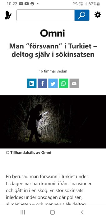 Silhuett av en person som deltar i en sökinsats i en skog på natten med en ficklampa.