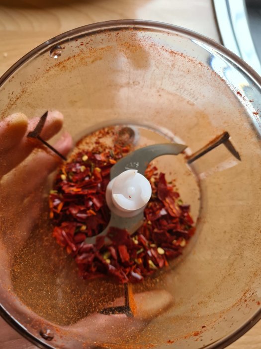 Chiliflakes och chilipulver i en mixerbunke, rostande med stark färgning.