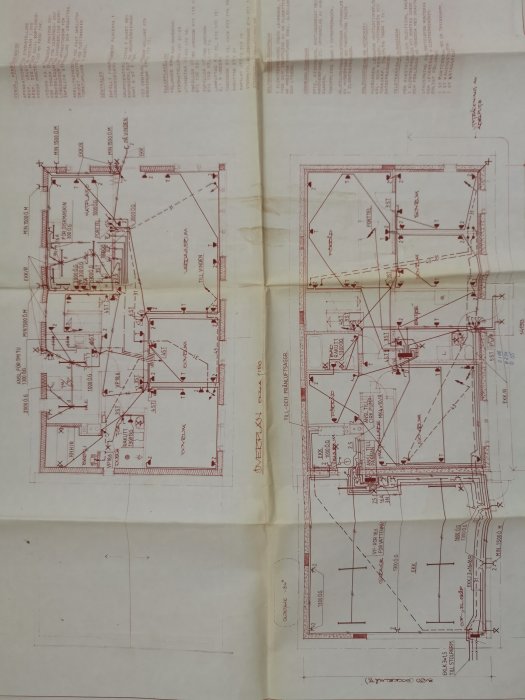 Ritningar med tekniska detaljer och mått för ett byggprojekt, uppslagna på ett bord.