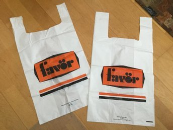 Två vita plastkassar med logotypen "Favor" i orange och svart från 60-70-talet.