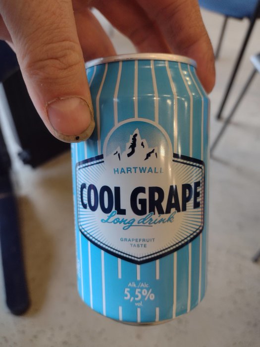 Hand håller en burk Hartwall Cool Grape long drink med grapefruktsmak.