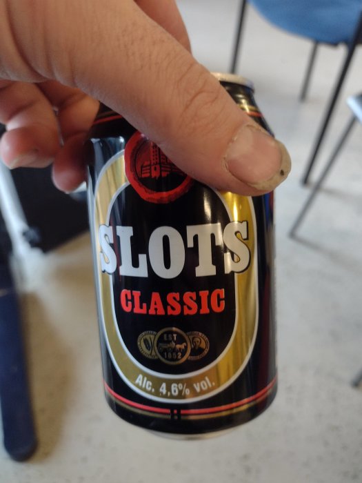 Hand håller en burk Slots Classic öl.