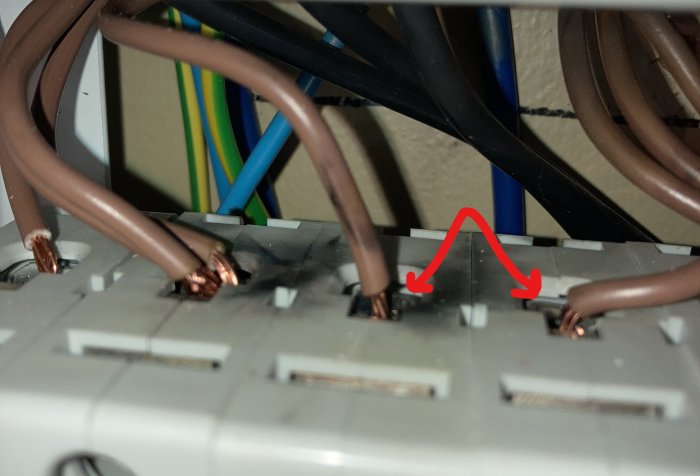 Svetsmärken på säkringar i elcentral indikerade med röda pilar efter strömavbrott vid renovering.