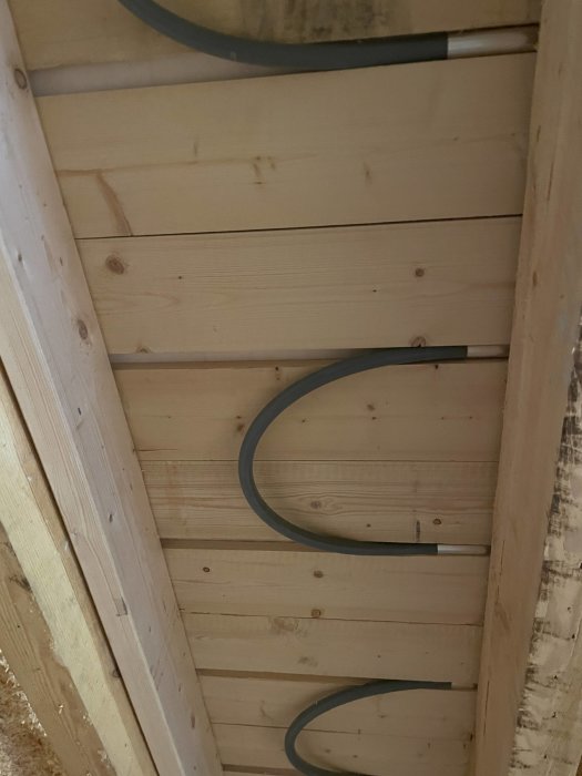 Rör för vattenburen golvvärme ovanpå träbjälkar utan fräsning.