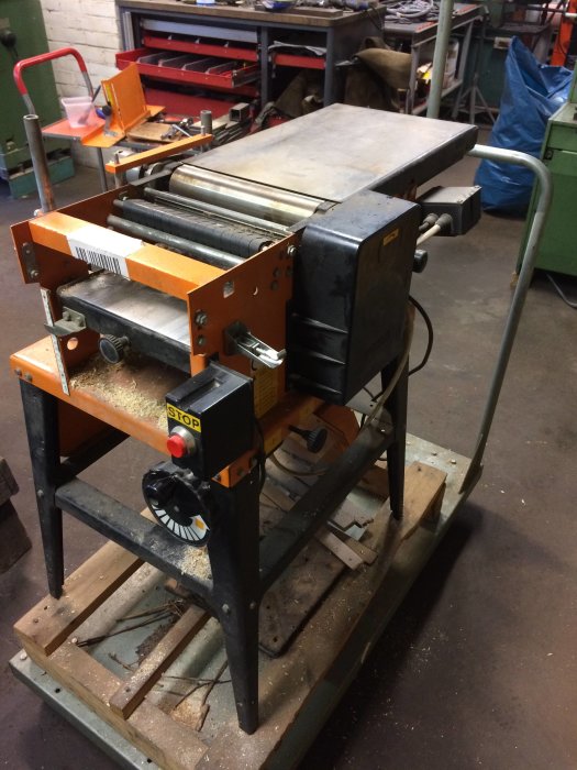 Planhyvel i verkstad utan fast bord, synliga valsar och justerbara styrplatser.