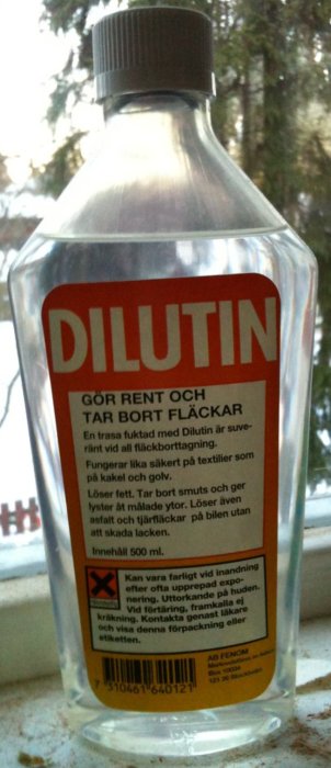 Flaska med etikett för Dilutin, en produkt för att ta bort fläckar och smuts.