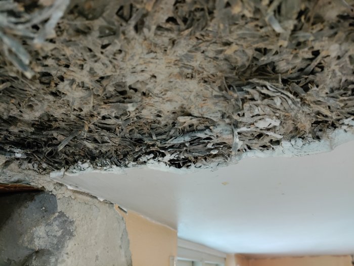 Skadat innertak med exponerad heraklit och taggig betongyta efter rivning, behöver lagning.