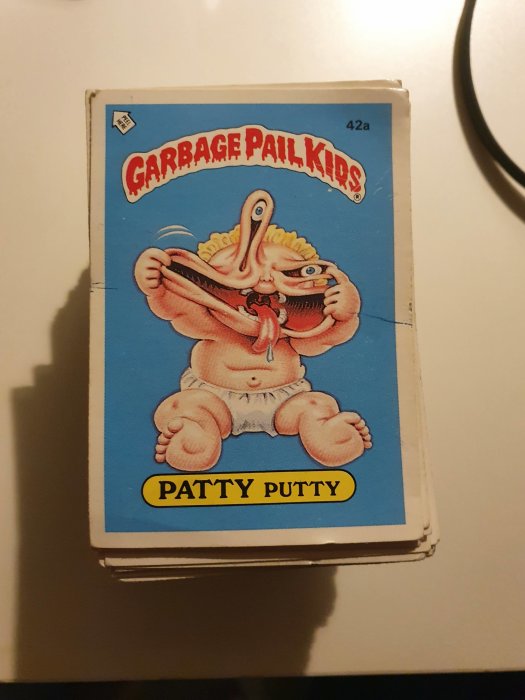 Stabel av samlarkort med Garbage Pail Kids, överst kortet visar karaktären Patty Putty.