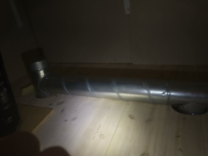 Ventilationsrör i tak med för stort utsågat hål och synliga fingerspetsar som pekar på glipan.