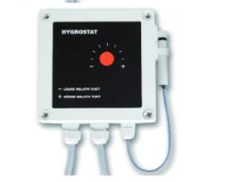 Hygrostat med rött vred och justerbar inställning för luftfuktighet, monterad på en vägg.